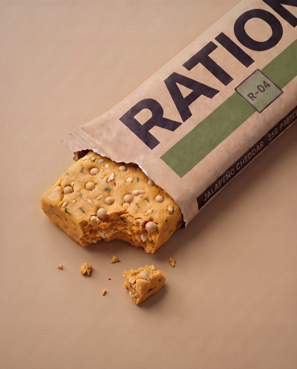 Studio render of the R-04 Jalapeno Cheddar bar peeking out of its torn-open printed wrapper: the flavor band color across the matte-paper pack, imperfect hand-pressed edges and a few crumbs on a neutral studio background.